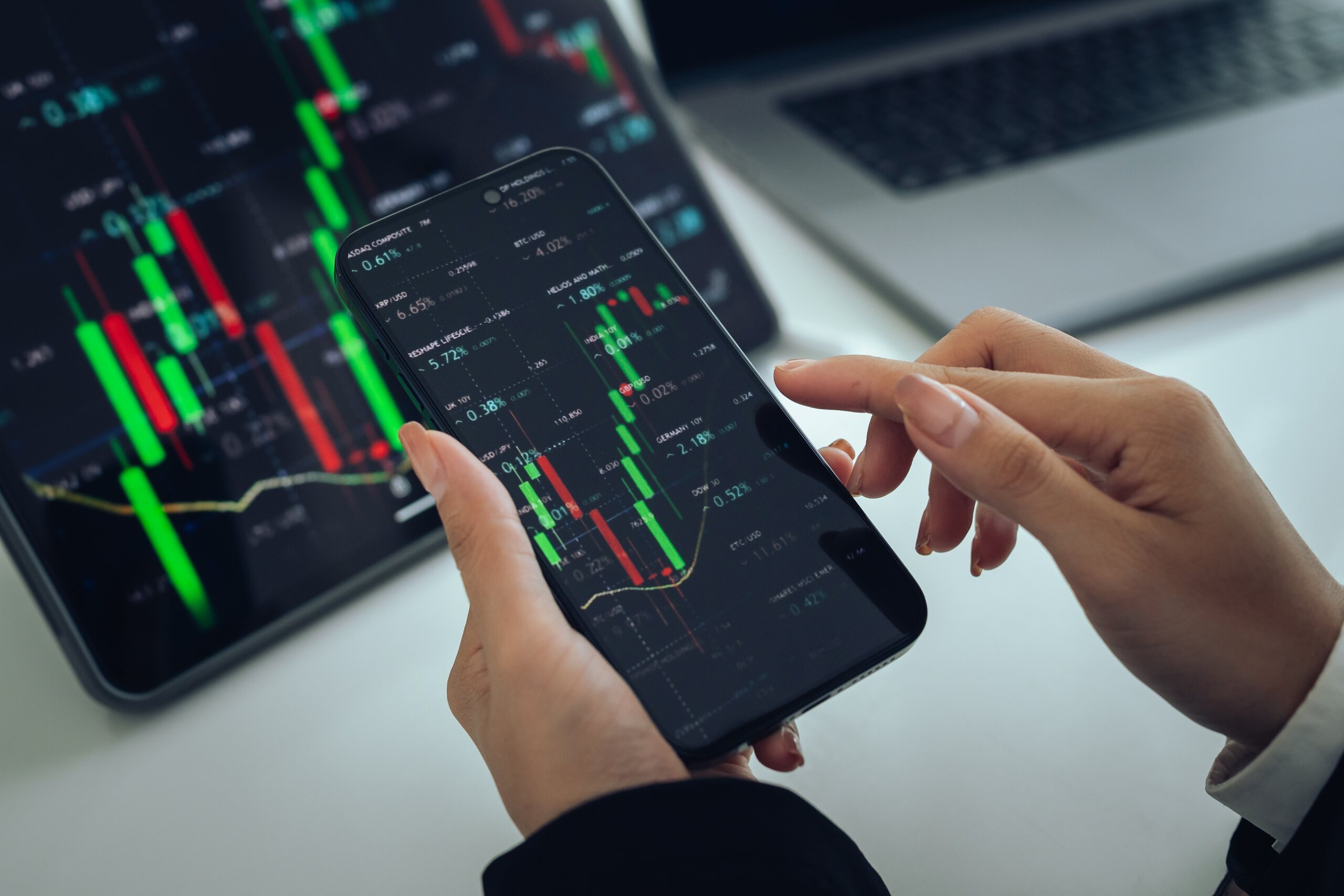 An investor checks stock market charts on a smartphone after experiencing GWG Holdings L Bonds losses.