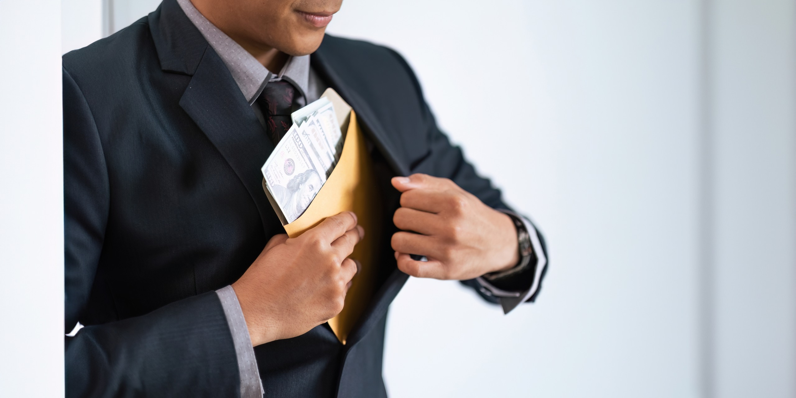 Puppeteer hand controlling a wooden figure above a trap illustrating conflicts in broker-dealer vs. Registered Investment Advisor roles.